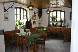 a dining room with tables and chairs and windows at Gasthaus & Hotel Zur Linde in Hermsdorf