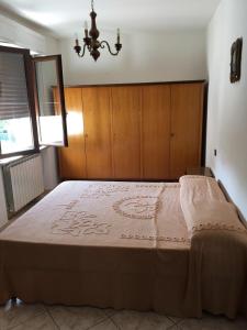 1 dormitorio con 1 cama grande y cabecero de madera en Appartamento Biancospino, en Gualdo Tadino