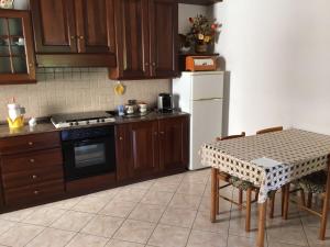 cocina con mesa, fogones y nevera en Appartamento Biancospino, en Gualdo Tadino