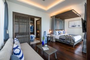 a living room with a bed and a couch at NH Collection Samui Peace Resort in Bophut