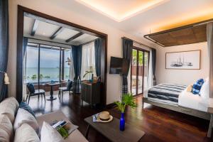 a hotel room with a bed and a living room at NH Collection Samui Peace Resort in Bophut