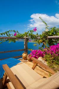 a wooden bench sitting on a deck with pink flowers at Fidanka Hotel in Kalkan