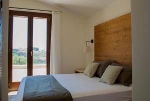 Santa NinfaにあるFeudo Del Biviereのベッドルーム1室(大きなベッド1台、大きな窓付)