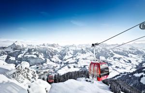two gondolas on a ski lift in the snow at Tennerhof Luxury Chalets in Kitzbühel