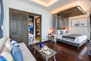 a bedroom with a bed and a living room at NH Collection Samui Peace Resort in Bophut