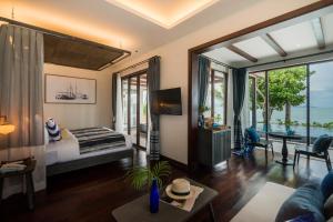 a bedroom with a bed and a living room at NH Collection Samui Peace Resort in Bophut