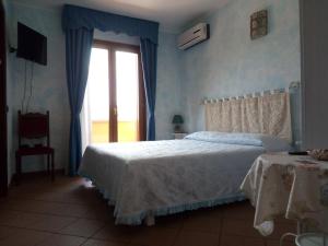 a bedroom with a white bed and a window at Grotta Delle Fate in Ossi
