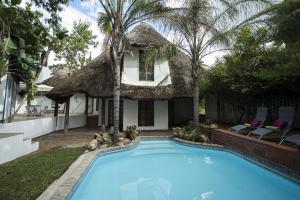 a house with a swimming pool in front of a house at Out of Africa Guesthouse in Otjiwarongo