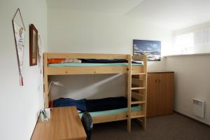 a room with two bunk beds and a table at Apartman Flora in Benecko