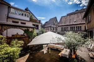 eine Terrasse mit einem weißen Regenschirm und einer Bank in der Unterkunft Ulner Kapelle in Weinheim
