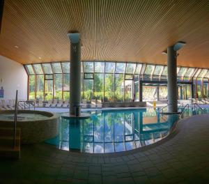 a pool in the middle of a building with windows at Hotel Špik in Kranjska Gora