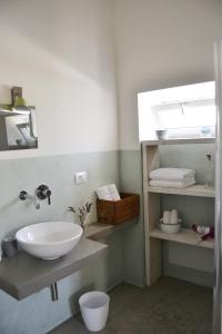 a bathroom with a sink and a shelf with towels at Masseria San Martino in Polignano a Mare