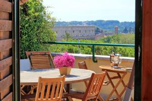 a table and chairs on a balcony with a view at Mecenate Charme Apartment in Rome