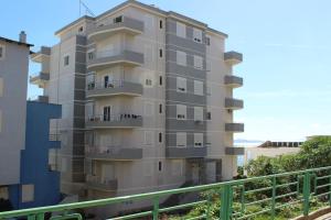 a tall apartment building with a balcony at Port Side Sarande in Sarandë