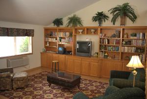 a living room with a tv and book shelves at Americas Best Value Inn in Annandale