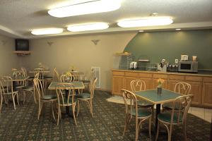 a dining room with tables and chairs and a kitchen at Americas Best Value Inn in Annandale