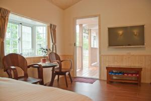 a bedroom with a bed and a television and a table at 林家莊民宿 in Lugu Lake