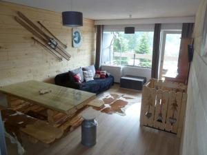 a living room with a blue couch and a table at Appart Eterlou Chamrousse in Chamrousse