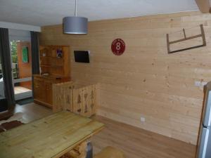 a room with a wooden wall with a wooden table at Appart Eterlou Chamrousse in Chamrousse