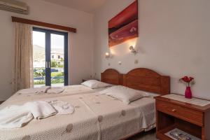 帕琉喬拉的住宿－Roula Apartments，一间卧室设有一张大床和一个窗户。