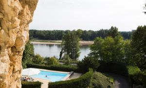 une vue sur une piscine et un lac dans l'établissement Hotel Les Hautes Roches, à Rochecorbon