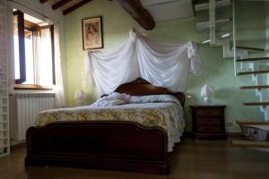 ein Schlafzimmer mit einem Himmelbett in der Unterkunft B&B Il Poggetto in Montespertoli