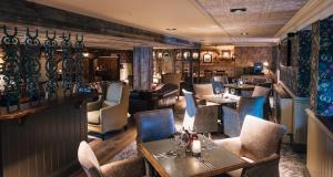 a restaurant with tables and chairs and a bar at Bowfield Hotel and Spa in Howwood