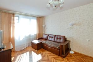 モスクワにあるApartamienty na Azovskoi 9k2のリビングルーム(革張りのソファ、窓付)