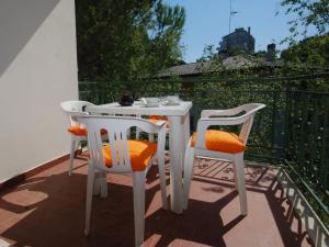 リニャーノ・サッビアドーロにあるVilla Lilianaの白いテーブルとバルコニー(椅子2脚付)