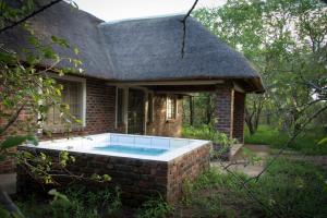 a brick house with a swimming pool in front of it at Impalas Walk in Marloth Park