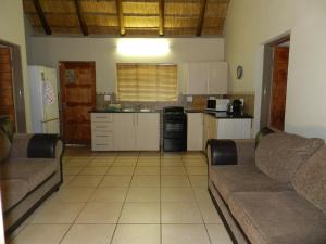 a living room with two couches and a kitchen at Impalas Walk in Marloth Park