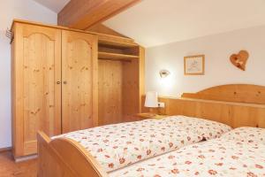 1 dormitorio con 1 cama y armario de madera en Landhaus Lindl - Ein ruhiges Platzl zum Wohlfühlen, en Leutasch