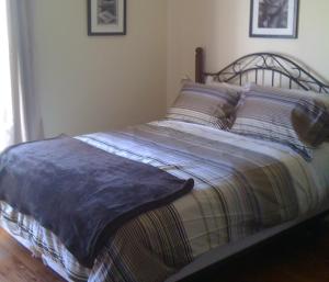 Dominion Hotel في Minden: سرير عليه بطانية في غرفة النوم