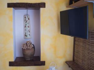 a vase sitting on a shelf next to a tv at La Chiocciola in Trentinara