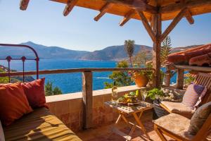 a porch with a couch and a table with a view of the ocean at Fidanka Hotel in Kalkan