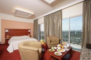 a hotel room with a bed and a table and chairs at Padova Hotel in Beirut