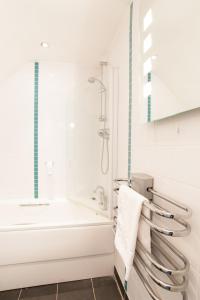 biała łazienka z wanną i prysznicem w obiekcie Unicorn, Gunthorpe by Marston's Inns w mieście Lowdham