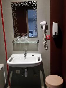 een badkamer met een wastafel en een telefoon aan de muur bij Hotel Prince de Liege in Brussel