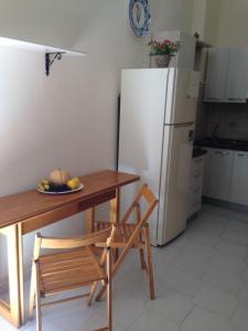 a kitchen with a table and a white refrigerator at Flowers apartment in Tropea