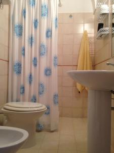 a bathroom with a toilet and a sink and a shower curtain at Flowers apartment in Tropea
