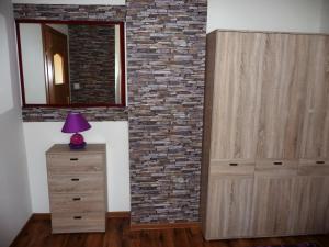 a room with a brick wall and a dresser and a mirror at Domek Miłka in Jastrzębia Góra