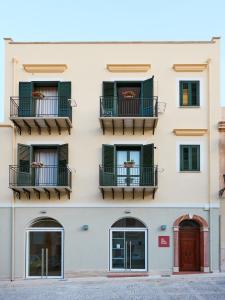 an apartment building with windows and balconies at Ai Gradini Affittacamere in Castellammare del Golfo
