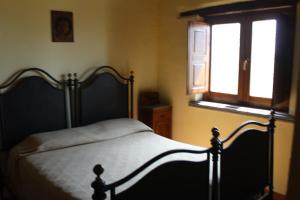 un letto in una camera da letto con finestra e copriletto di Casetta ai Malvitani a Cetraro