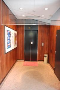 un pasillo con un ascensor negro en un edificio en Kojima Puchi Hotel, en Kurashiki