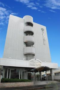 a white building with balconies on the side of it at Kojima Puchi Hotel in Kurashiki