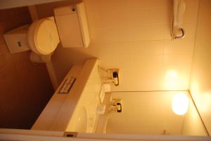 Baño pequeño con aseo y lavamanos en Kojima Puchi Hotel, en Kurashiki