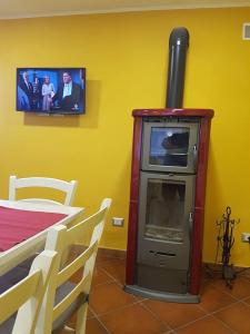 una chimenea en una habitación con TV en la pared en AleKS friendly house en Canale