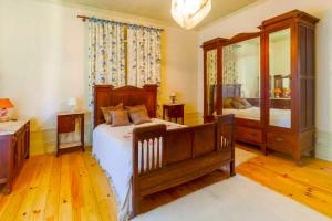 um quarto com uma cama e um espelho grande em Porto Countryside House em Aguiar de Sousa