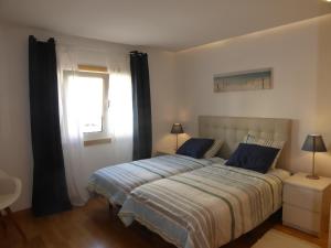 アルブフェイラにあるGarden Hill M by Check-in Portugalのベッドルーム1室(青い枕のベッド1台、窓付)