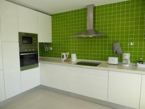 アルブフェイラにあるGarden Hill M by Check-in Portugalの白いキャビネットと緑のタイルを用いたキッチン